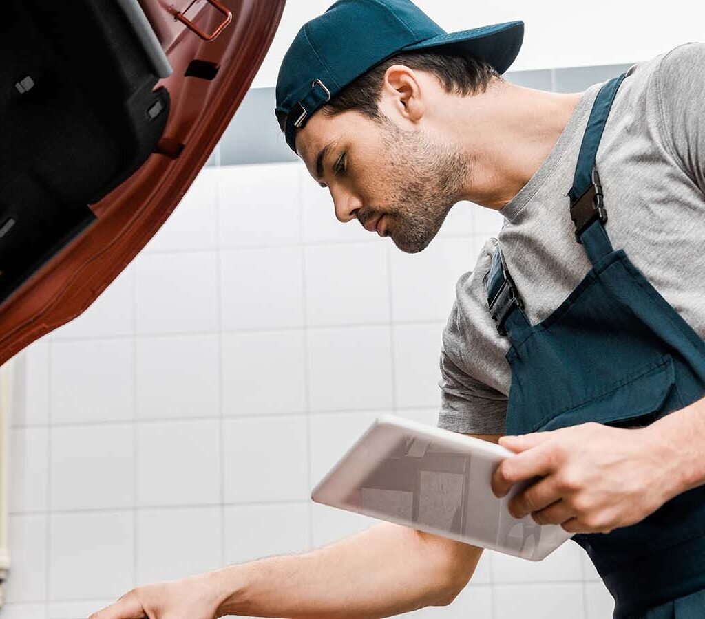 side-view-of-auto-mechanic-with-tablet-checking-ca-CJFYZUR.jpg